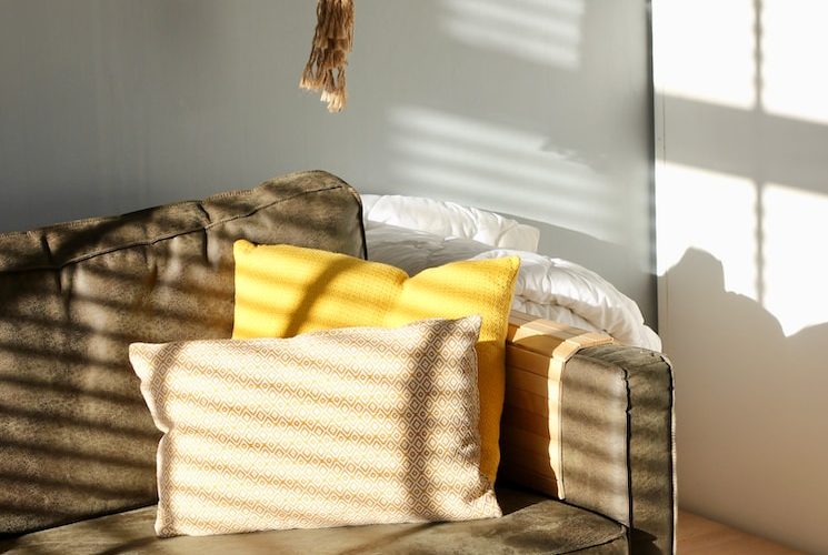 two white and yellow pillows on gray sofa