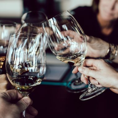 group of people holding footed glasses