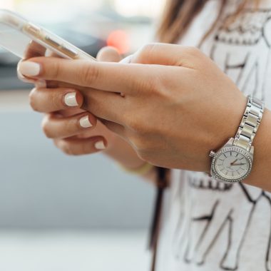 woman holding iPhone during daytime