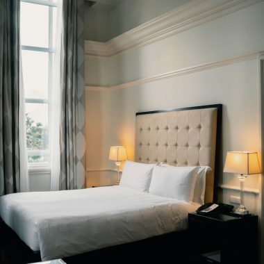 white bed linen near black wooden nightstand