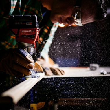 person holding orange and black power tool