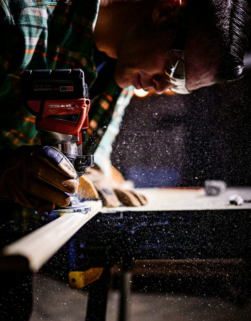 person holding orange and black power tool