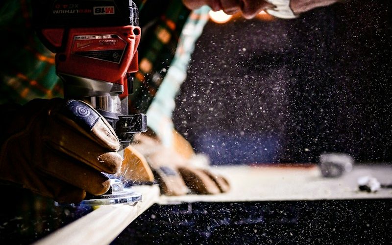 person holding orange and black power tool