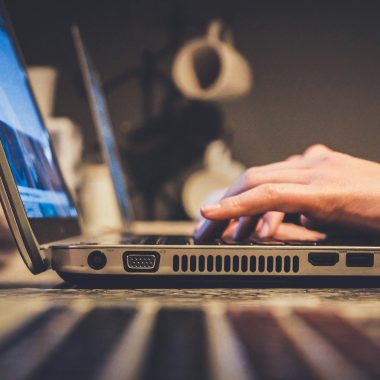 person using silver laptop computer on desk