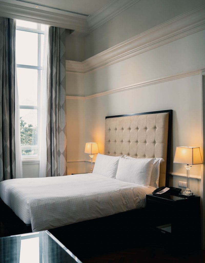 white bed linen near black wooden nightstand