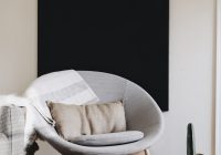 round grey moon chair with brown pillow on top