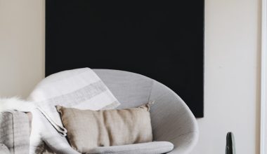 round grey moon chair with brown pillow on top