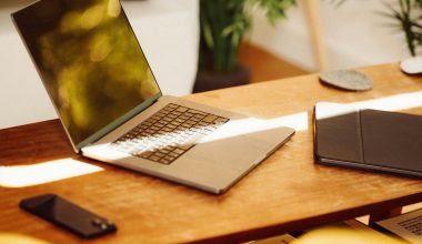 A laptop computer sitting on top of a wooden desk