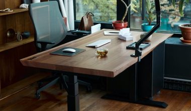 a desk with a laptop on it in front of a window