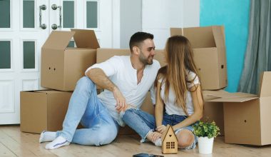 Couple surrounded by moving boxes in new home