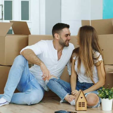 Couple surrounded by moving boxes in new home