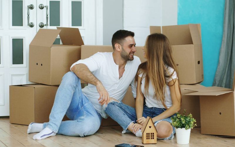 Couple surrounded by moving boxes in new home