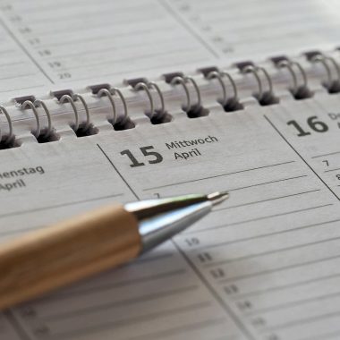Verbouwplanning op papier met seizoenskalender en bouwtekeningen op tafel