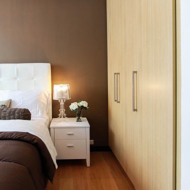 Dimbare slaapkamerlamp naast een wandschakelaar in een sfeervolle slaapkamer