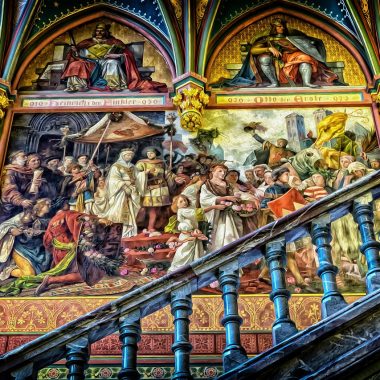 Galerijwand met diverse ingelijste kunstwerken en spiegels boven een bed in een slaapkamer