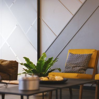 Een rustige woonkamer met licht hout, linnen kussens en een matte keramieken vaas in Japandi-stijl