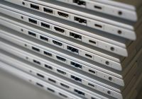 Iemand maakt een USB-C oplaadpoort schoon met een tandenstoker en perslucht